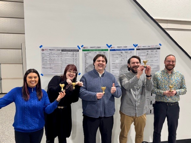 Workshop team celebrating with trophies